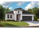 Beautiful single-story home with a modern design, dark roof, a two car garage, and a well-manicured lawn at 12158 Cattleside Dr, Riverview, FL 33579