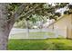 Landscaped backyard with a well-maintained fence, beautiful trees, and lush green grass at 12506 Safari Ln, Riverview, FL 33579