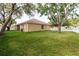 Expansive backyard with green grass surrounding the home, complemented by mature trees at 12506 Safari Ln, Riverview, FL 33579