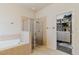 Bathroom with tub, framed glass shower and opening to walk-in closet at 12506 Safari Ln, Riverview, FL 33579