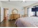 Bedroom with wood floor, ornate dresser, and opening to other rooms at 12506 Safari Ln, Riverview, FL 33579
