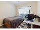 Bedroom with a bed, a window with blinds, hardwood floors, and a desk with a computer at 12506 Safari Ln, Riverview, FL 33579