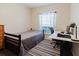 Bedroom with a twin bed, white desk, a modern black desk chair and gray striped rug at 12506 Safari Ln, Riverview, FL 33579