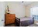 Bedroom with a twin bed, wooden dresser, and view of the backyard through the window at 12506 Safari Ln, Riverview, FL 33579