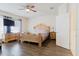 A cozy bedroom with a large wooden bed frame, matching nightstands, and a window dressed with elegant gray curtains at 12506 Safari Ln, Riverview, FL 33579