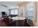 The bright dining area features large windows with a ceiling fan, complemented by a modern gray sofa in the background at 12506 Safari Ln, Riverview, FL 33579