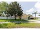 Home exterior featuring a lush lawn, mature trees, and a well-maintained front yard at 12506 Safari Ln, Riverview, FL 33579