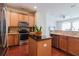 Well-equipped kitchen boasts stainless steel appliances, wooden cabinets, an island, and a seamless open floor plan at 12506 Safari Ln, Riverview, FL 33579