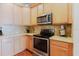 This kitchen features stainless steel appliances, tile backsplash, light wooden cabinets, and stone countertops at 12506 Safari Ln, Riverview, FL 33579