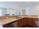 The kitchen features stainless appliances, light stone countertops, a bar, and seamlessly leads into a bright dining room at 12506 Safari Ln, Riverview, FL 33579