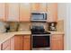Bright kitchen showcasing stainless steel oven, microwave, and ample counter space with a stylish tiled backsplash at 12506 Safari Ln, Riverview, FL 33579
