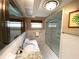 Bright bathroom featuring a walk-in shower, granite countertop and elegant tiled walls at 13930 King Ave, Hudson, FL 34669