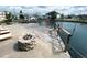 A serene dock featuring a stone fire pit on the water, perfect for relaxing and entertaining guests at 13930 King Ave, Hudson, FL 34669