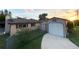 Cozy home featuring a detached garage, storage shed, and a well-maintained lawn at 13930 King Ave, Hudson, FL 34669