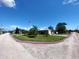 A charming single-story home featuring lush green lawn, several palm trees, and an American flag at 13930 King Ave, Hudson, FL 34669