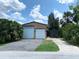 Large two-car garage with ample parking space surrounded by lush greenery and a gravel driveway at 13930 King Ave, Hudson, FL 34669