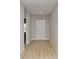 Inviting hallway with new, light-colored hard wood floors and neutral paint provides access to all parts of the home at 14773 Summer Branch Dr, Lithia, FL 33547