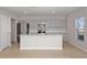 Modern kitchen features stainless steel appliances, a large island, and light gray cabinets at 14773 Summer Branch Dr, Lithia, FL 33547