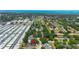 An aerial view of a home with a screened-in pool in a suburban neighborhood near a school and the ocean at 1509 Coachlight Way, Dunedin, FL 34698