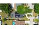 Aerial view of a single-Gathering home with a screened-in pool and solar panels on the roof in a lush neighborhood at 1509 Coachlight Way, Dunedin, FL 34698