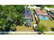 An aerial view of a home that includes a screened-in pool, solar panels and a fenced-in yard at 1509 Coachlight Way, Dunedin, FL 34698