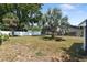 The serene backyard boasts lush landscaping and mature trees creating a private outdoor space at 1509 Coachlight Way, Dunedin, FL 34698