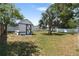 Fenced backyard featuring storage shed and a large palm tree at 1509 Coachlight Way, Dunedin, FL 34698