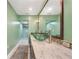 Bathroom with double bowl sinks, granite countertop, framed mirror, and glass enclosed shower at 1509 Coachlight Way, Dunedin, FL 34698