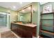 Bathroom vanity with double sinks, granite countertop, framed mirror and dark wood cabinets at 1509 Coachlight Way, Dunedin, FL 34698
