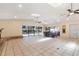 Bright living room with tile floors, brick fireplace, skylights, ceiling fans, dining table and access to the pool at 1509 Coachlight Way, Dunedin, FL 34698