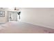 Spacious living area with neutral carpeting, sliding door access to outdoor area, and minimalistic decor at 1509 Coachlight Way, Dunedin, FL 34698