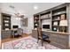 Charming home office with custom built-in shelving, a comfortable desk, and a stylish accent rug at 1509 Coachlight Way, Dunedin, FL 34698