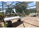 Screened in pool and hot tub with brick deck and covered seating area at 1509 Coachlight Way, Dunedin, FL 34698
