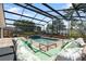 Screened in pool and hot tub with brick deck and lush landscaping at 1509 Coachlight Way, Dunedin, FL 34698