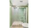 Bathroom shower with hexagon tile, glass doors and bronze hardware at 1509 Coachlight Way, Dunedin, FL 34698