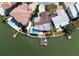 Aerial perspective of a modern home with a pool, boat dock, and manicured lawn nestled between waterfront properties at 16496 Redington Dr, Redington Beach, FL 33708