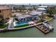 Aerial shot of modern waterfront home featuring a sleek pool, stylish deck, and private dock with a boat at 16496 Redington Dr, Redington Beach, FL 33708