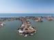 Stunning aerial view of waterfront community, showcasing luxurious home with pool and private dock on a peninsula at 16496 Redington Dr, Redington Beach, FL 33708