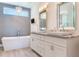 Elegant bathroom with a chandelier over the tub and a stylish vanity with dual sinks at 16496 Redington Dr, Redington Beach, FL 33708