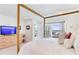 White bedroom with a wooden canopy bed, water views, and light wood dresser at 16496 Redington Dr, Redington Beach, FL 33708