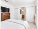 Minimalist bedroom featuring a bed, a dresser, a TV, and two closets at 16496 Redington Dr, Redington Beach, FL 33708