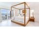 Light, bright bedroom with a wooden canopy bed and views of the water at 16496 Redington Dr, Redington Beach, FL 33708