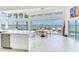 Bright dining area features waterfront views, a modern table set, and sliding glass doors to the pool at 16496 Redington Dr, Redington Beach, FL 33708