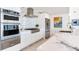Modern kitchen featuring stainless steel appliances and a white marble countertop island with a tiled backsplash at 16496 Redington Dr, Redington Beach, FL 33708