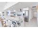 Kitchen with marble countertop island, stainless steel appliances and white cabinets, and barstool seating at 16496 Redington Dr, Redington Beach, FL 33708