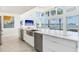 Bright, white kitchen island with marble countertops, stainless steel appliances, and water views at 16496 Redington Dr, Redington Beach, FL 33708