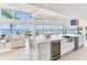 Modern kitchen with a large marble island, stainless steel appliances, and waterfront views at 16496 Redington Dr, Redington Beach, FL 33708