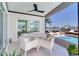 Covered patio with outdoor dining and pool access make a luxurious waterfront living space at 16496 Redington Dr, Redington Beach, FL 33708