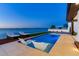 Modern waterfront pool with in-pool loungers, surrounded by stylish patio furniture and lush landscaping at 16496 Redington Dr, Redington Beach, FL 33708