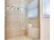 Close-up of a stylish shower with tiled walls, a built-in bench, and glass door at 16496 Redington Dr, Redington Beach, FL 33708